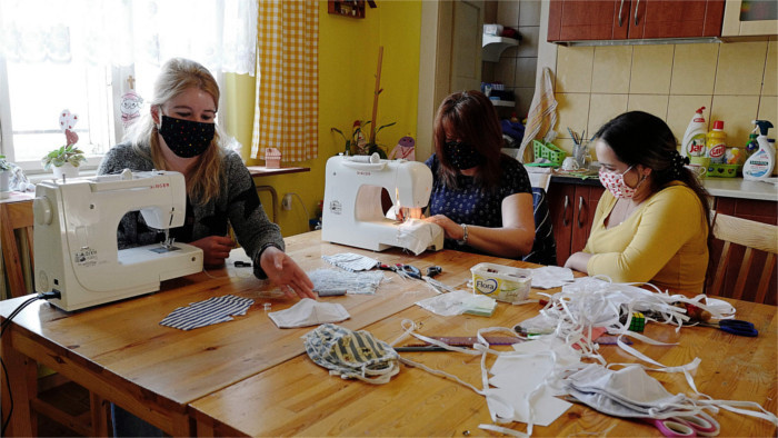 Muchachas romanís de una asociación cívica cosen máscaras