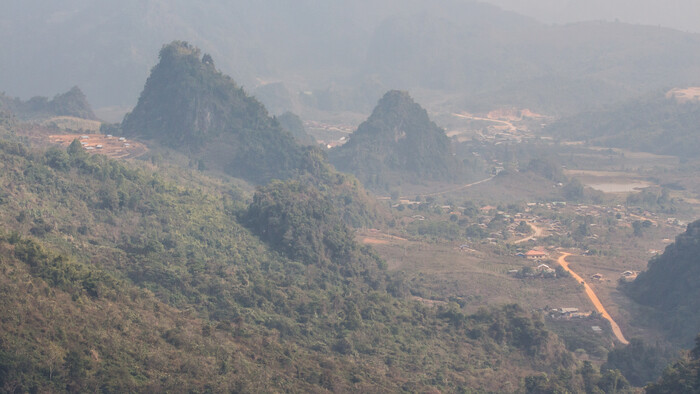výhľad na Long Tieng - zahmlenosť fotky je spôsobená tým, že následkom vypaľovania lesov je veľmi vysoká prašnosť.jpg