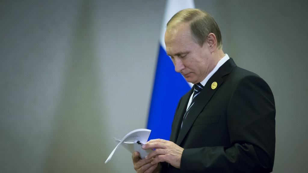 Vladimir Putin pred vlajkou Ruska.